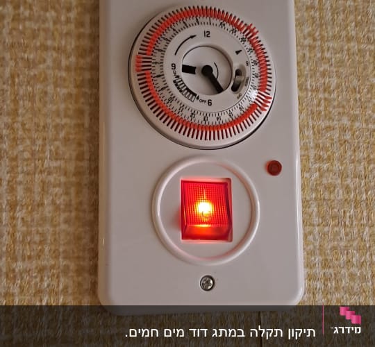שעון טיימר עם מתג מואר על קיר